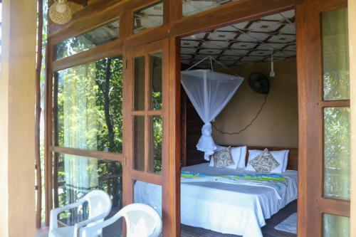 a room with a bed with an umbrella at Nice View guest house & restaurant in Ella