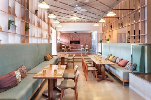 a restaurant with wooden tables and chairs and a bar at The Level at Meliá Villaitana in Benidorm