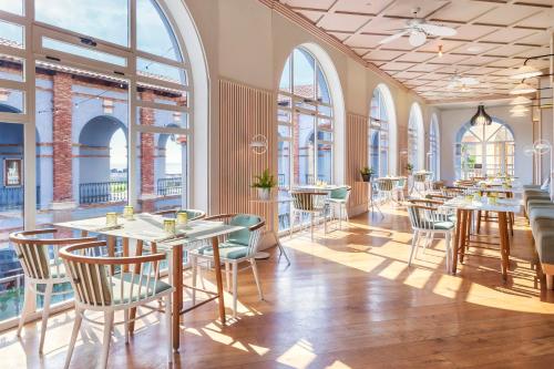 a restaurant with tables and chairs and large windows at The Level at Meliá Villaitana in Benidorm