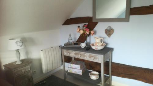 a room with a table with a vase of flowers on it at La Gerbaudiere Chambres&Table d hotes proche Mont Saint Michel CUISINE MAISON in Notre-Dame-du-Touchet