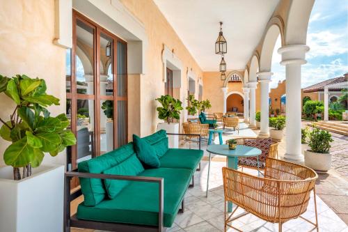 a patio with a couch and tables and chairs at The Level at Meliá Villaitana in Benidorm