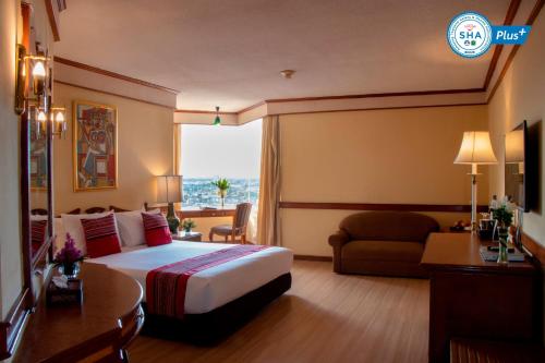 a hotel room with a bed and a couch at Duangtawan Hotel Chiang Mai in Chiang Mai