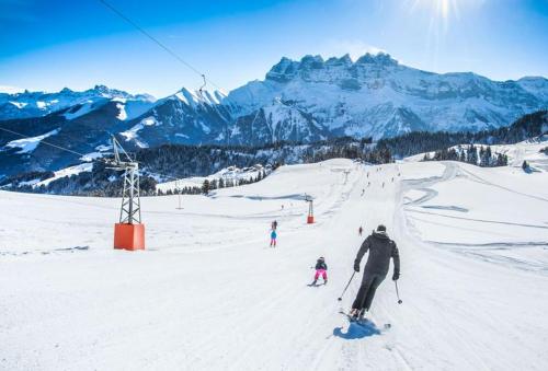 a group of people skiing down a snow covered mountain at Backpacker Le Petit Baroudeur in Champéry