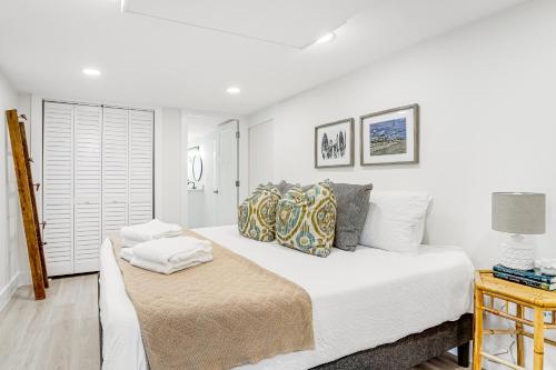 a white bedroom with a bed and a window at Folly's Hideaway A in Folly Beach