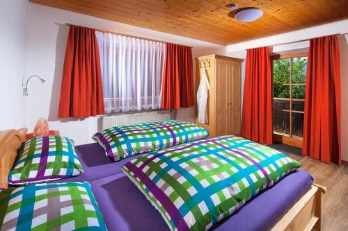a bedroom with two beds and a window with red curtains at Hartlerlehen Rasp in Berchtesgaden