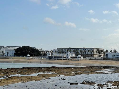 a view of a beach with buildings in the background at San Lorenzo Apartamentos y Suites in Cádiz