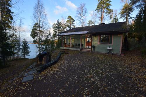 a small house on the side of a lake at Pyhtään Vuokramökit in Tuuski