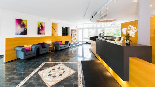 a living room with two couches and a counter at Hotel Schützenhof in Eitorf