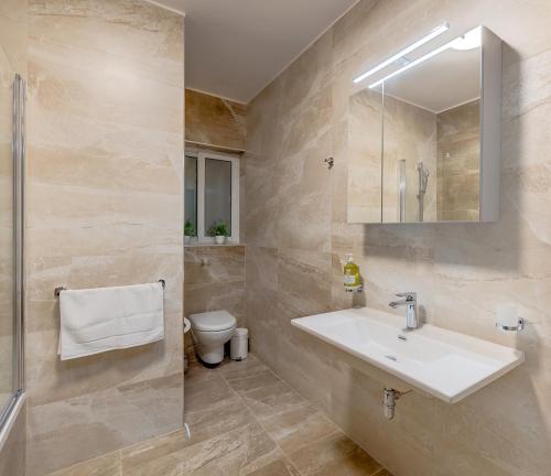 La salle de bains est pourvue d'un lavabo et de toilettes. dans l'établissement Chic 2BR Apartment, Ideal Location, à Taʼ Xbiex