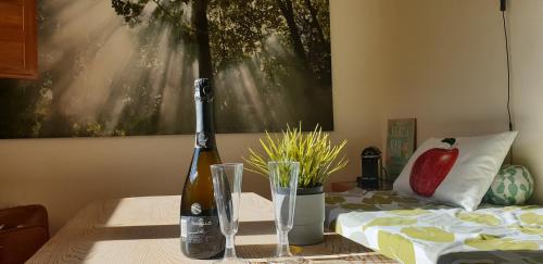a bottle of wine sitting on a table next to a bed at Finca Olivar de Castilla - Sun&Colors in Segovia
