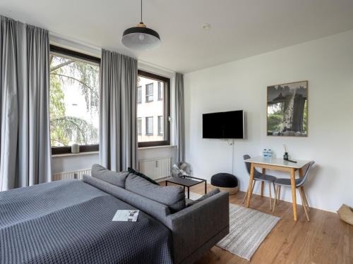 a bedroom with a bed and a desk and a tv at Limehome Aachen Vereinsstraße in Aachen