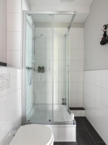 a white bathroom with a shower and a tub at Limehome Aachen Vereinsstraße in Aachen