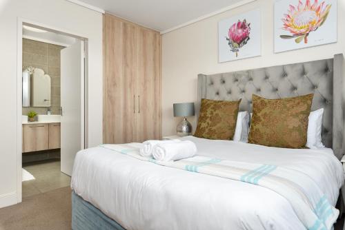 a bedroom with a large bed with towels on it at Waters Edge Apartments in Cape Town