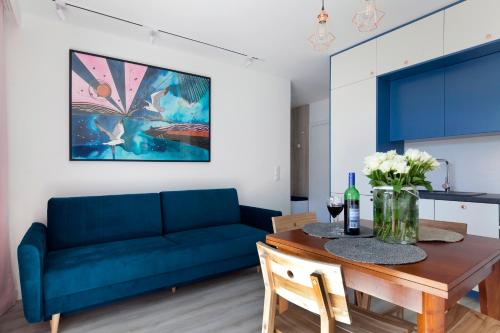 a living room with a blue couch and a table at Elite Apartments Brzeźno Premium in Gdańsk