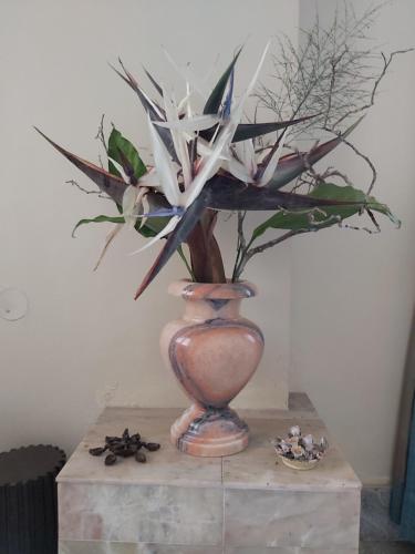 a vase with a plant in it on a table at Tarana Homestay in Gonikoppal