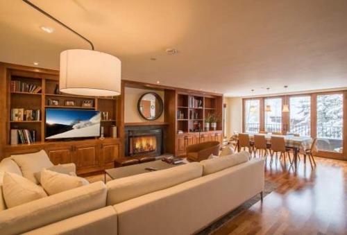a living room with a large couch and a fireplace at Northwoods Easy Ski In Ski Out Access in Vail
