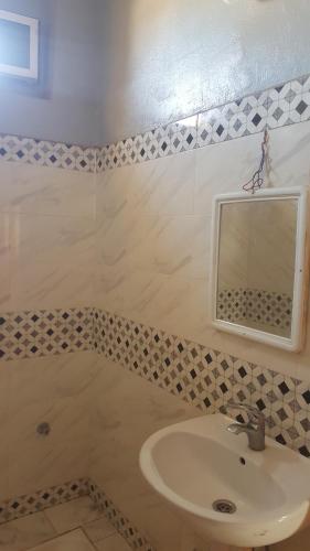a bathroom with a sink and a mirror at Chez Said (Happy People) Apartment in Merzouga