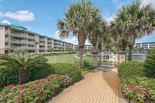 a resort with palm trees and flowers in front of a building at Amalfi Coast in Miramar Beach