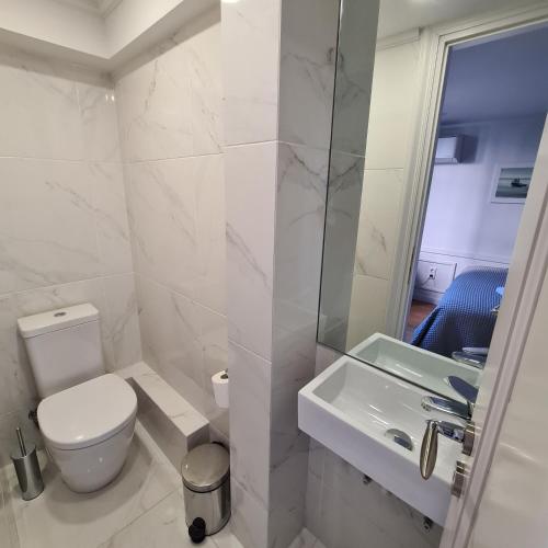 a white bathroom with a toilet and a sink at Four Streets Athens - Luxury Suites Apartments in Athens in Athens