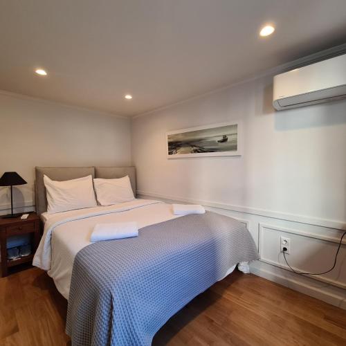 a bedroom with a bed with a blue and white blanket at Four Streets Athens - Luxury Suites Apartments in Athens in Athens