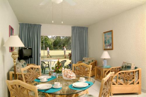 a living room with a glass table and chairs at Plum Tree Club in Bridgetown