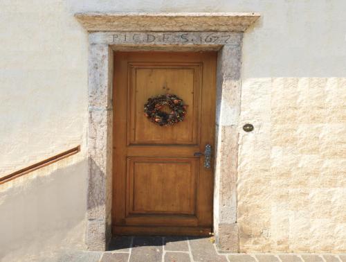 a wooden door with a wreath on it at Hotel Zur Kirche in Magrè allʼ Adige