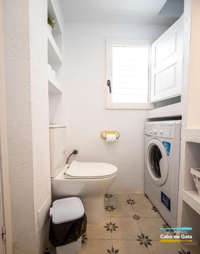 a bathroom with a toilet and a washing machine at Casa AMARILLA in San José