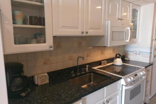 a kitchen with white cabinets and a sink at Decatur House in Ocean City