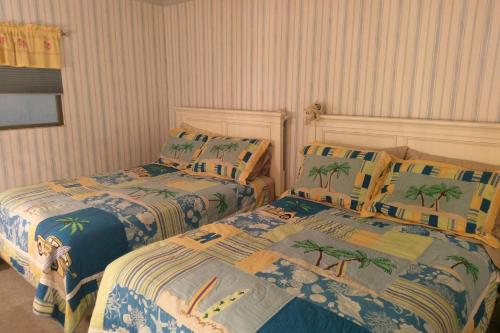 een slaapkamer met twee bedden met palmbomen erop bij Decatur House in Ocean City