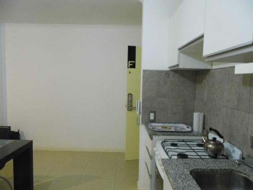 a kitchen with a stove and a sink at Ayres de Las Sierras in Villa Carlos Paz