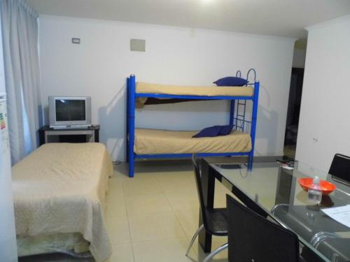 a room with two bunk beds and a desk at Ayres de Las Sierras in Villa Carlos Paz