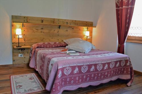 a bedroom with a large bed with a wooden headboard at La Maison De José in Aosta