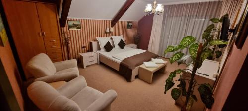 a hotel room with a bed and two chairs at Ilmar House in Cluj-Napoca
