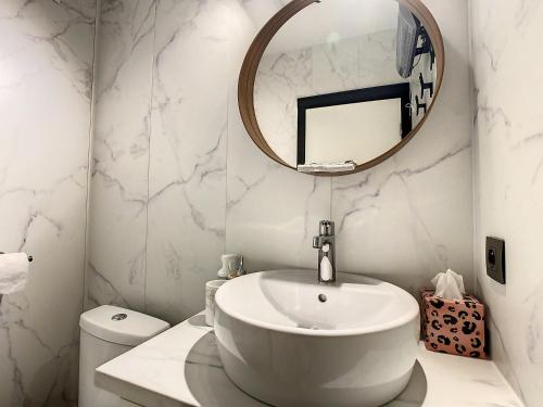 bagno bianco con lavandino e specchio di Studio enjoy 55 a Nieuwpoort