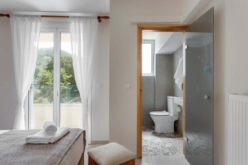 a bathroom with a bed and a toilet and a window at Villa 4 DESTINA in Élos