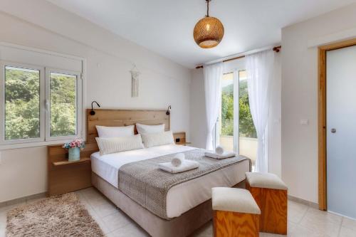 a bedroom with a large bed and windows at Villa 4 DESTINA in Élos