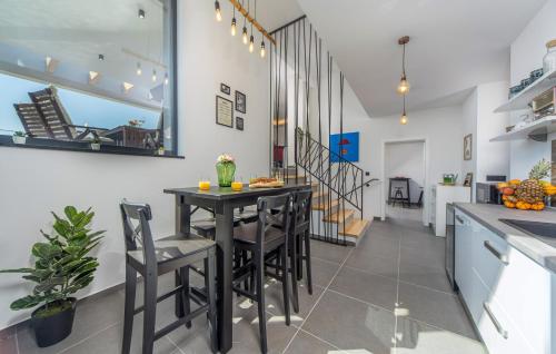 a kitchen and dining room with a black table and chairs at Villa Nina in Šmrika