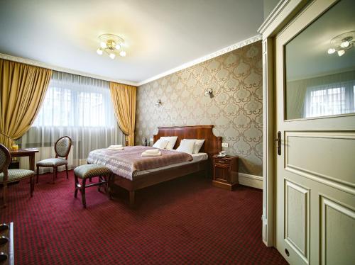 a bedroom with a bed and a table and chairs at ApartHotel Hubertus in Białystok