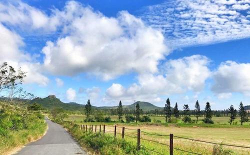 a road in the middle of a field with a fence at 獨棟山水心旅棧 in Kenting