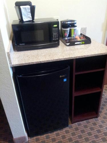 a microwave sitting on top of a kitchen counter at Cobblestone Inn & Suites - Hartington in Hartington
