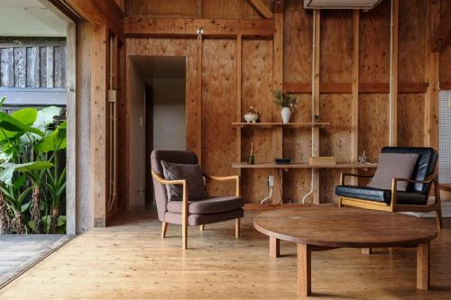 a living room with two chairs and a coffee table at 姉と弟の家 in Nanjo