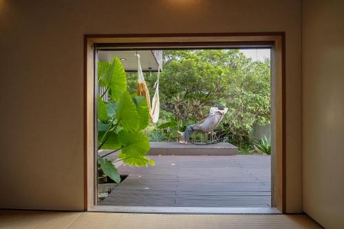 a door to a patio with a statue in the background at 姉と弟の家 in Nanjo