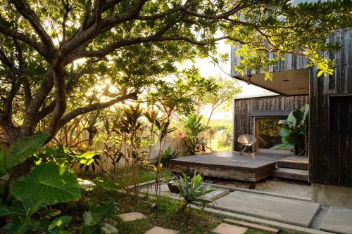 a house with a bench in the middle of a garden at 姉と弟の家 in Nanjo