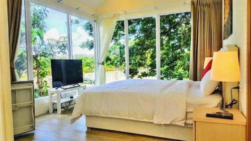 a bedroom with a bed and a large window at 獨棟山水心旅棧 in Kenting