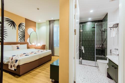 a bedroom with a bed and a shower and a bathroom at Palette Collect's Boutique Hotel Ha Long in Ha Long