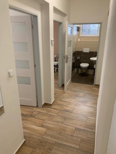 a hallway of a bathroom with a toilet and a sink at Golf Čertovo břemeno in Jistebnice