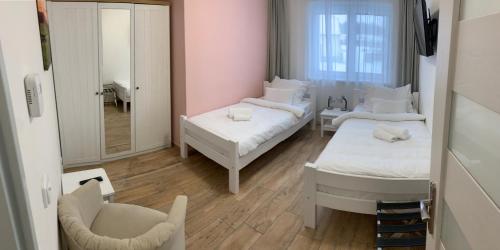 a room with two beds and a mirror and a chair at Golf Čertovo břemeno in Jistebnice