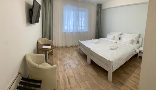 a bedroom with a large white bed and a chair at Golf Čertovo břemeno in Jistebnice