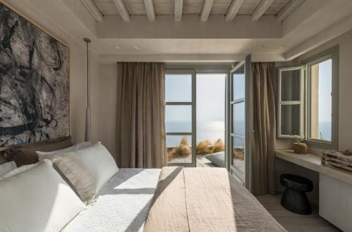 a bedroom with a bed with a view of the ocean at Verina Astra in Artemonas