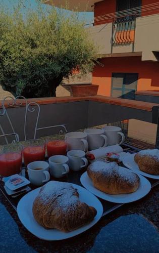 a table with three breads on plates and cups at Bed & Breakfast Neapolis in Ercolano